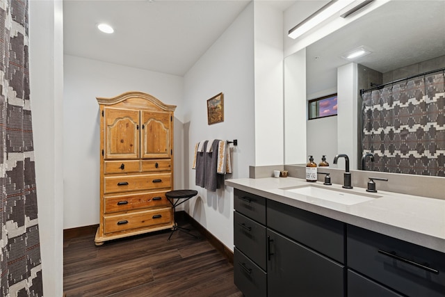 full bath featuring vanity, curtained shower, wood finished floors, and baseboards