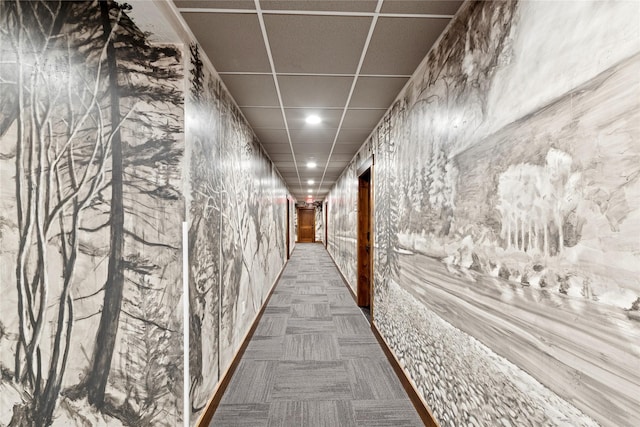 hall with carpet flooring and a drop ceiling