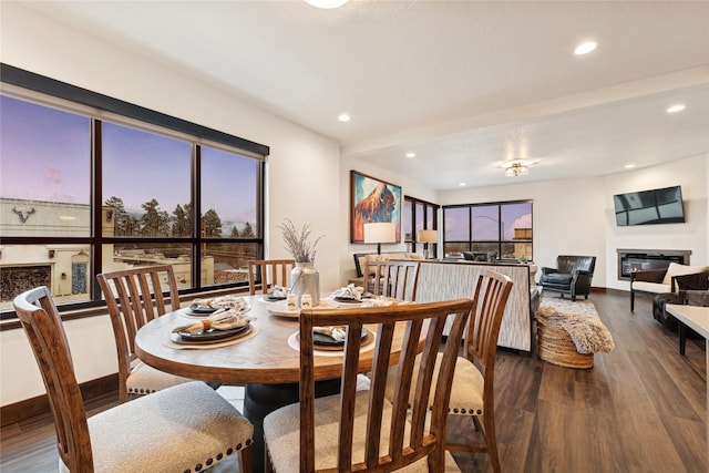 dining area with plenty of natural light, recessed lighting, a glass covered fireplace, and wood finished floors