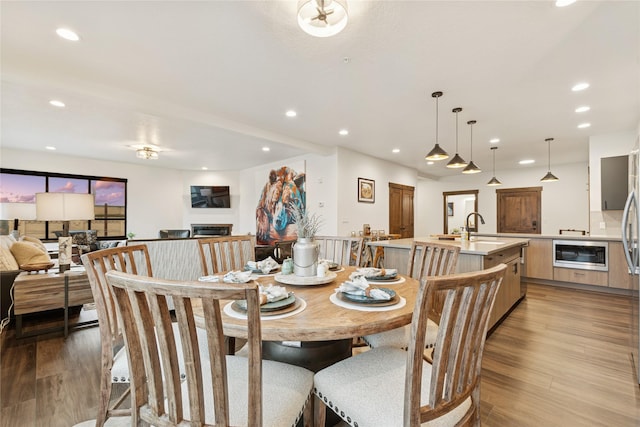 dining room with recessed lighting and light wood-style flooring