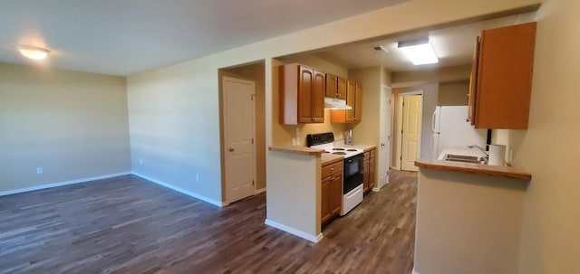 kitchen with baseboards, under cabinet range hood, light countertops, range with electric stovetop, and a sink
