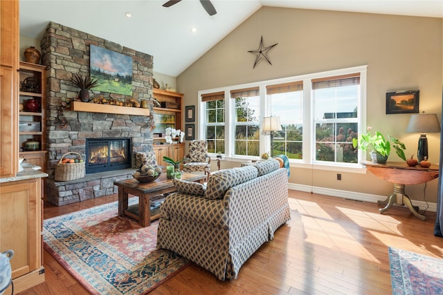 living room with light wood-style flooring, ceiling fan, and a fireplace