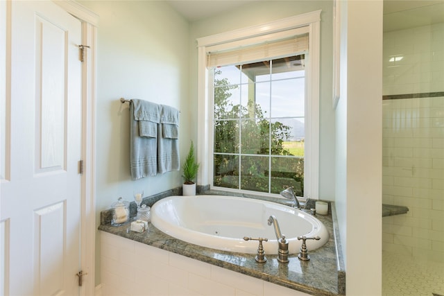 full bathroom with a jetted tub and a tile shower