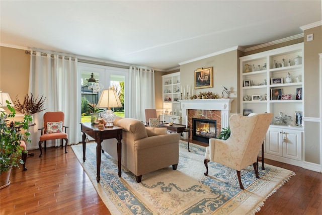 living room with hardwood / wood-style flooring, crown molding, and a fireplace