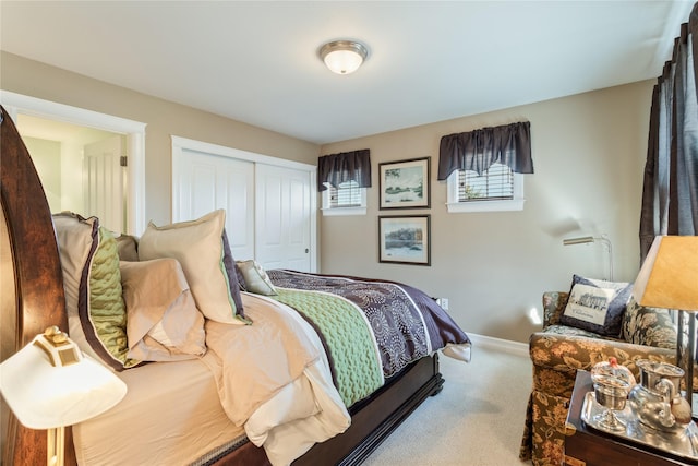 carpeted bedroom with a closet and baseboards