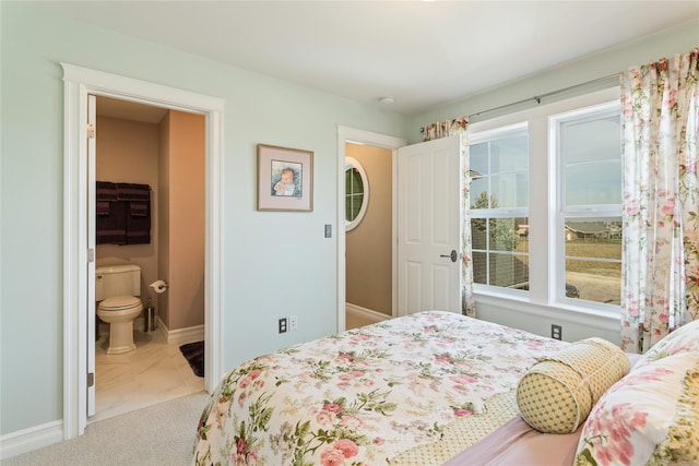 bedroom with ensuite bath, baseboards, and carpet floors