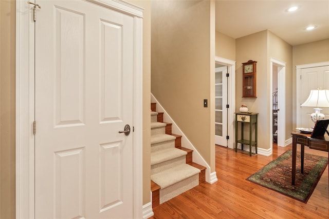 staircase featuring recessed lighting, wood finished floors, and baseboards