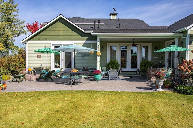 back of property featuring french doors, a yard, a shingled roof, and a patio area