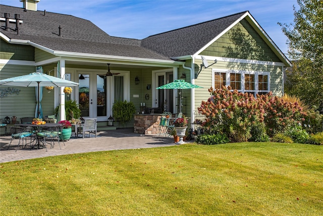 back of house featuring a ceiling fan, a patio, a yard, french doors, and a shingled roof