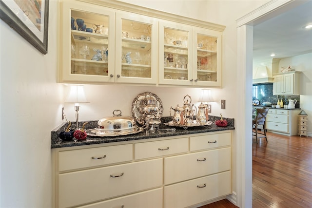 bar with dark wood finished floors, backsplash, and custom range hood