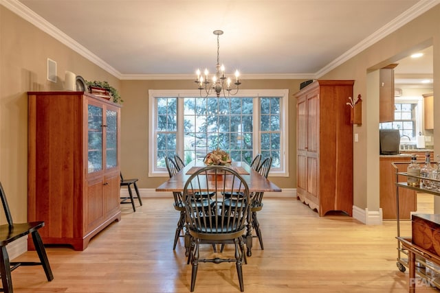 dining room with light wood-type flooring, baseboards, a chandelier, and ornamental molding