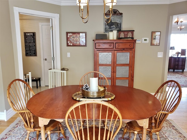 dining area with light wood-style floors and ornamental molding