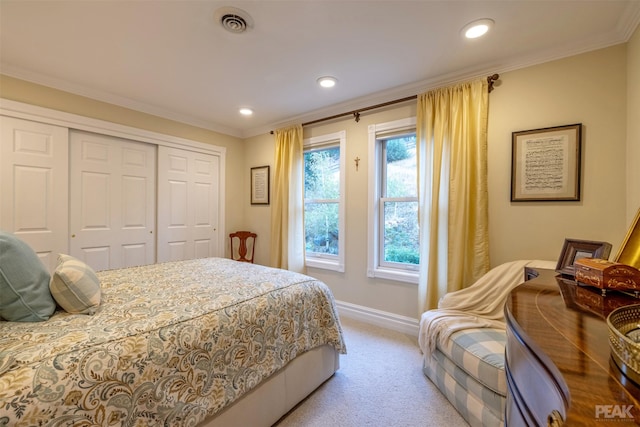 bedroom with a closet, baseboards, light colored carpet, and ornamental molding