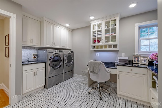 washroom featuring baseboards, washing machine and dryer, recessed lighting, cabinet space, and a sink