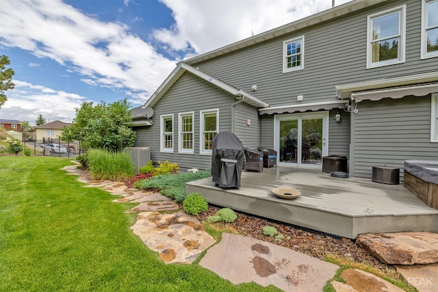 rear view of property with a deck, central AC unit, a lawn, and fence