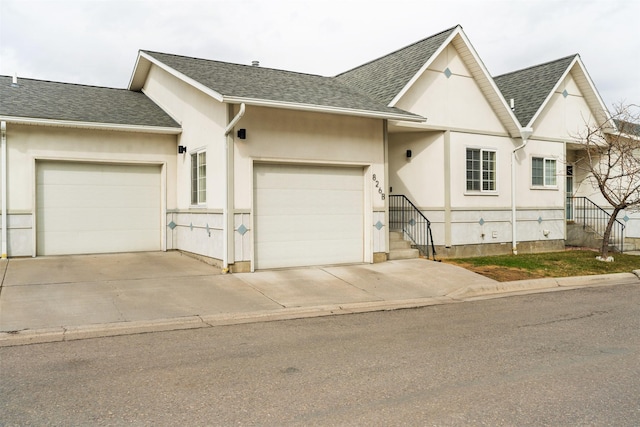 view of front of property with concrete driveway, an attached garage, and roof with shingles