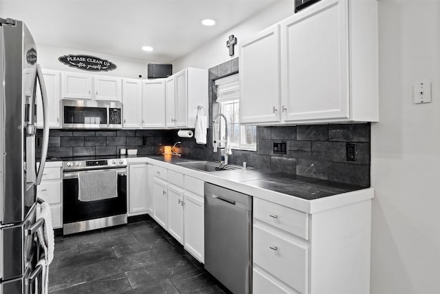 kitchen featuring a sink, tasteful backsplash, appliances with stainless steel finishes, and white cabinets