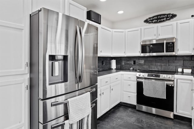 kitchen featuring dark countertops, white cabinets, tasteful backsplash, and appliances with stainless steel finishes