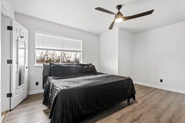 bedroom featuring wood finished floors, baseboards, and ceiling fan