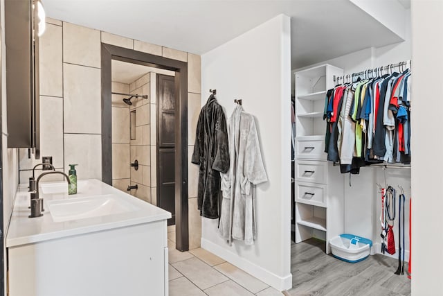 full bathroom featuring vanity, walk in shower, and a spacious closet