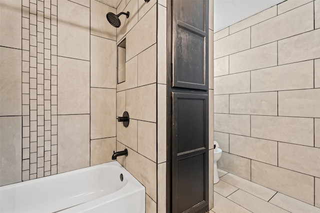 bathroom with tile walls, toilet, and tub / shower combination