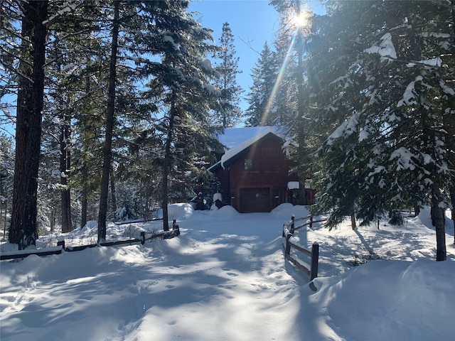 snowy yard featuring a garage