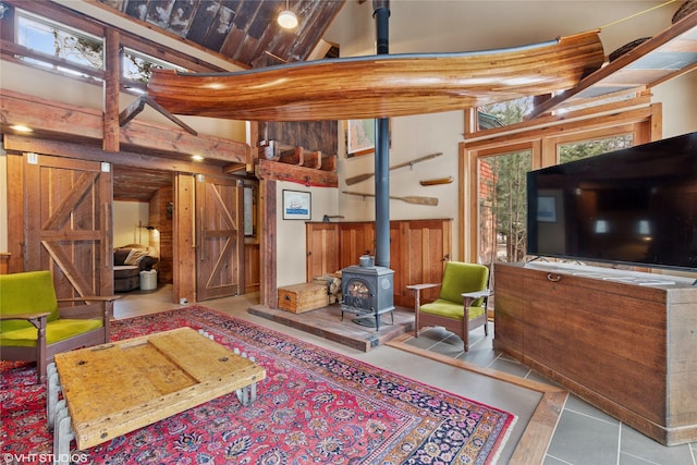 588 Ranch Rd, Bigfork, MT 59911 - tiled living room featuring a wood stove and a towering ceiling