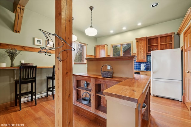 kitchen featuring light wood finished floors, wooden counters, freestanding refrigerator, and open shelves