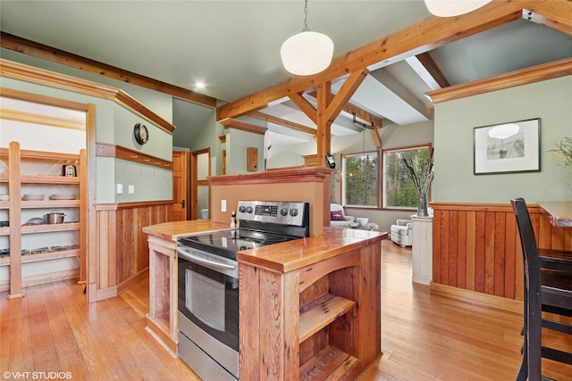 kitchen with a wainscoted wall, light wood-style floors, wood walls, stainless steel electric range oven, and vaulted ceiling with beams