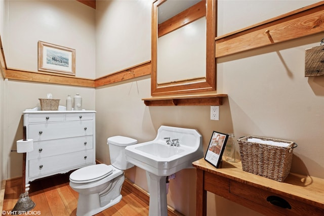 bathroom with toilet and wood finished floors