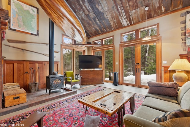 living room with wood ceiling, french doors, a wealth of natural light, and wainscoting