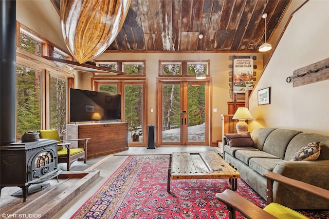 living area featuring wooden ceiling, a healthy amount of sunlight, french doors, and a wood stove