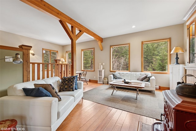 living room featuring beam ceiling, recessed lighting, light wood-style floors, and baseboards