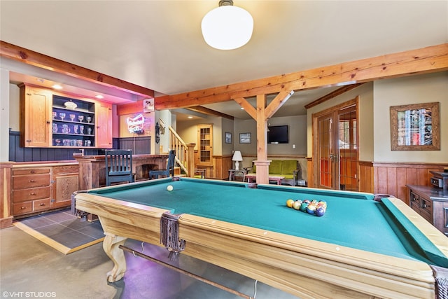 game room featuring pool table, a bar, beamed ceiling, and wainscoting