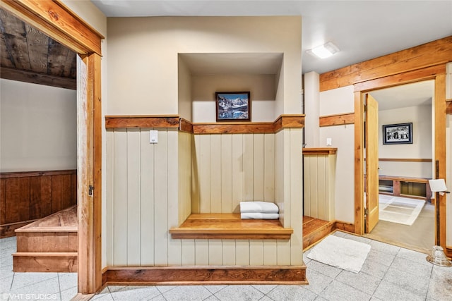 bathroom featuring tile patterned floors, wood walls, and wainscoting