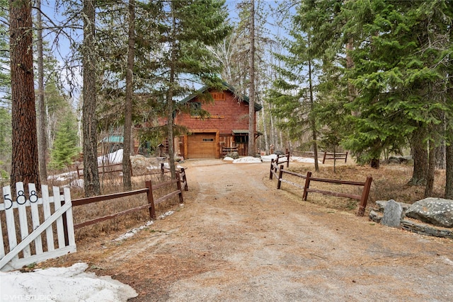 view of front of property with dirt driveway and fence