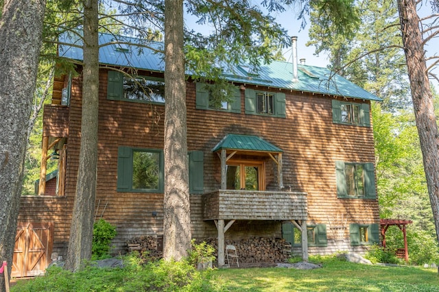 view of front of house with metal roof, a standing seam roof, and a front yard