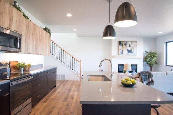 kitchen with visible vents, light wood-type flooring, a sink, open floor plan, and appliances with stainless steel finishes