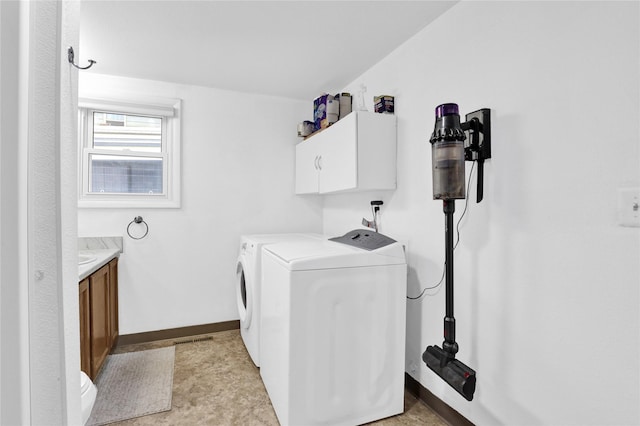 washroom featuring cabinet space, baseboards, and separate washer and dryer