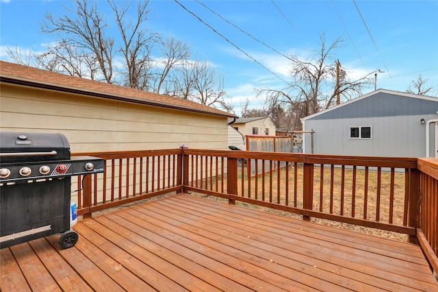 wooden terrace with an outbuilding and a grill