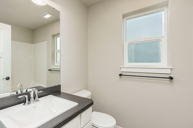 bathroom featuring visible vents, toilet, and vanity