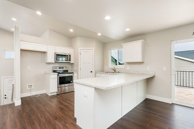 kitchen featuring a sink, appliances with stainless steel finishes, a peninsula, light countertops, and lofted ceiling