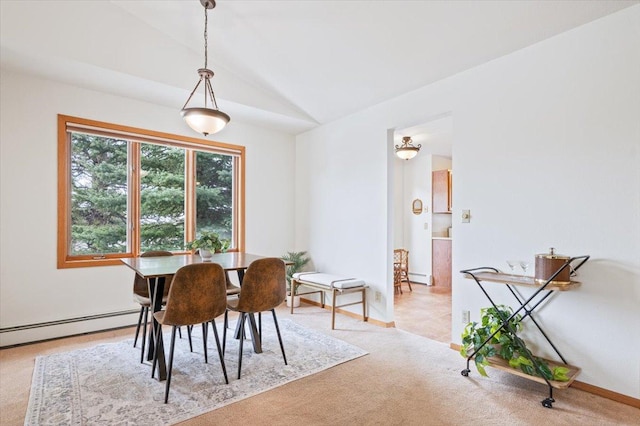 dining area with a baseboard heating unit, lofted ceiling, and light colored carpet