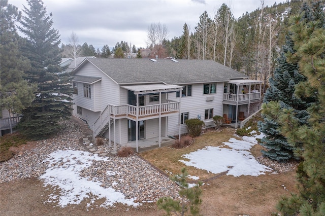 back of house featuring a deck, stairs, a patio area, and a shingled roof