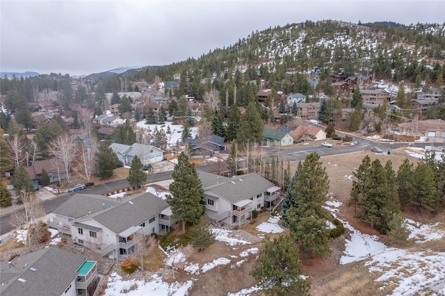 snowy aerial view featuring a residential view and a mountain view