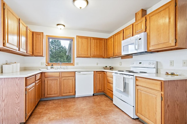 kitchen featuring light tile patterned floors, white appliances, a sink, and light countertops