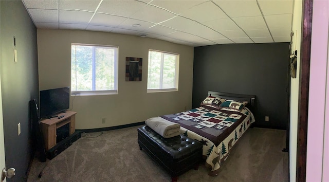 carpeted bedroom featuring a paneled ceiling and baseboards