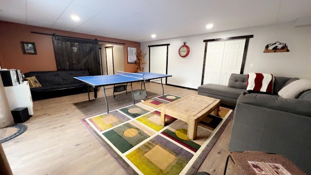 playroom featuring recessed lighting, a barn door, and wood finished floors