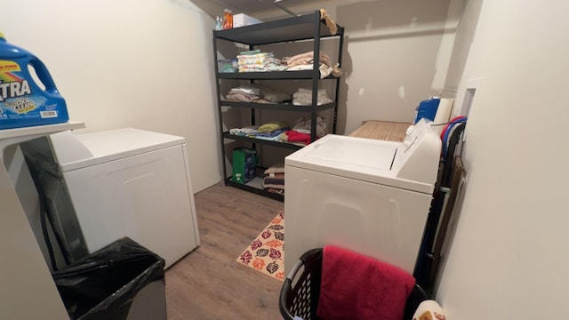 laundry area with washer and dryer, wood finished floors, and laundry area