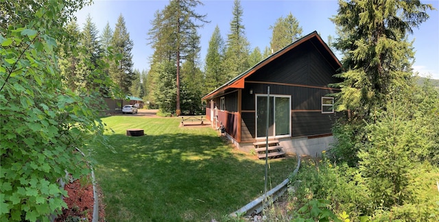 back of house featuring a lawn and entry steps